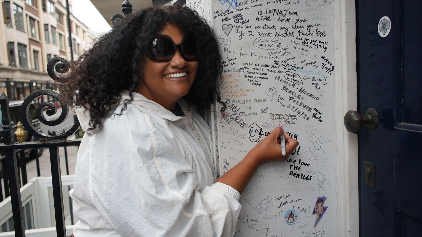 Beatles fan signing the Abbey Road wall during a London ebike Beatles tour