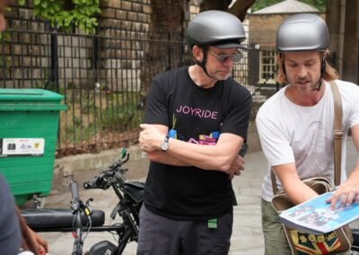 Guide showing Beatles archive photos to guests during a guided London e-bike tour