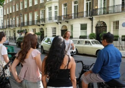 Guide sharing Beatles history with guests on a London e-bike tour near a blue plaque location