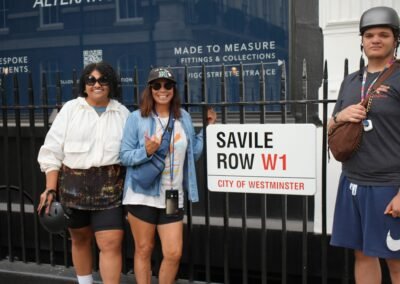 Guests posing beside the Savile Row street sign on a Beatles London tour
