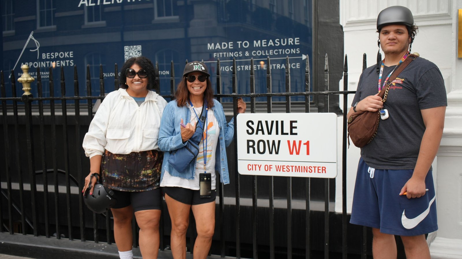 Guests posing beside the Savile Row street sign on a Beatles London tour