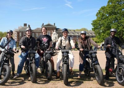 FOF Bike Tours guests on Super73 e-bikes in front of Kensington Palace during a guided London e-bike tour.