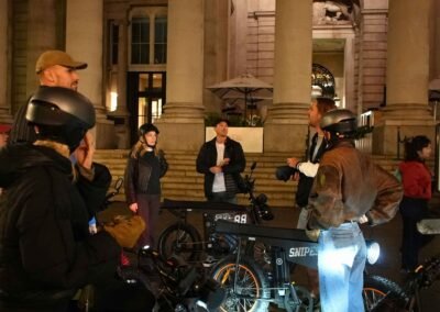 FOF Bike Tours guests listening to their guide during the Dickens Christmas e-bike tour at the Royal Exchange in London.