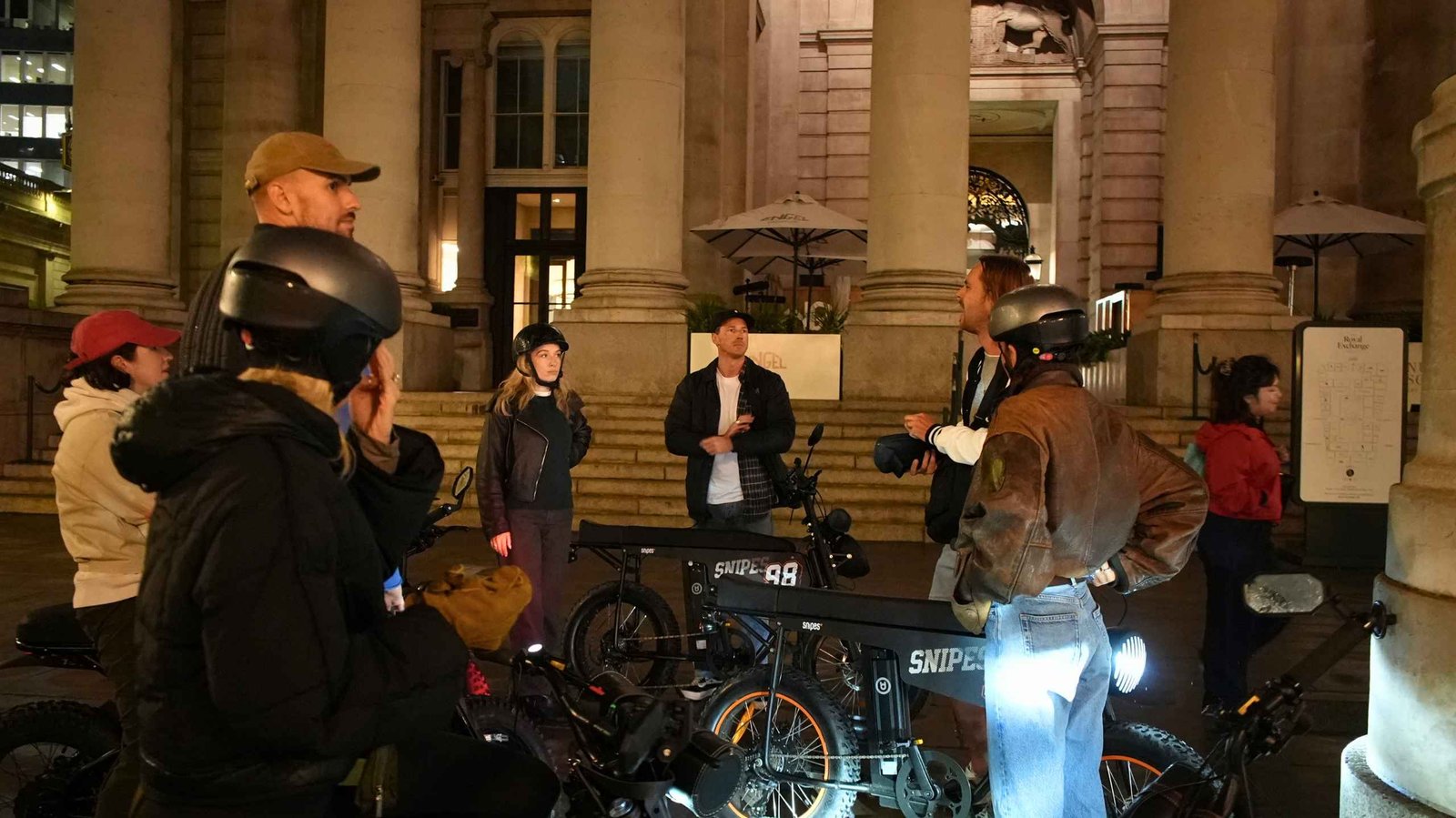 FOF Bike Tours guests listening to their guide during the Dickens Christmas e-bike tour at the Royal Exchange in London.