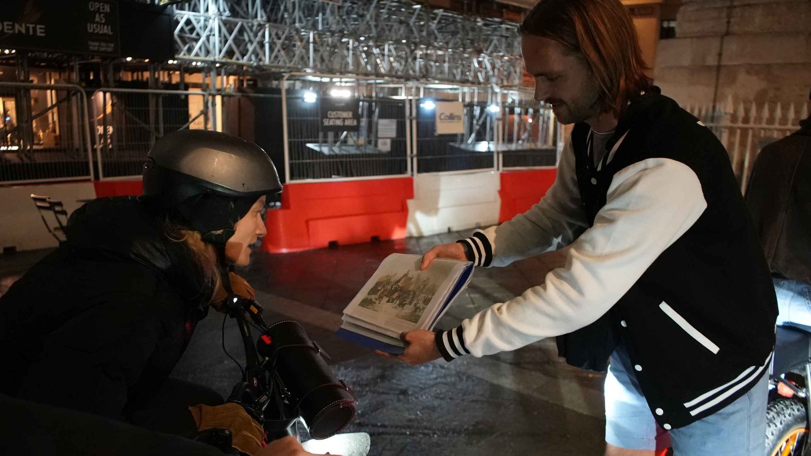 FOF Bike Tours guide showing historical material to a guest during the Dickens Christmas London e-bike tour.