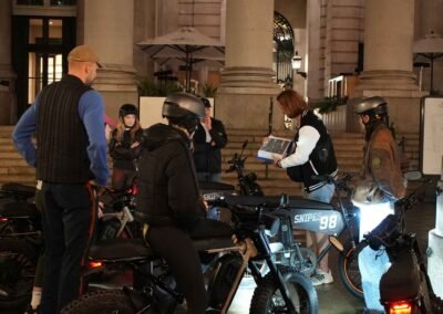 FOF Bike Tours guide showing historical material to guests during the Dickens Christmas e-bike tour at the Royal Exchange.