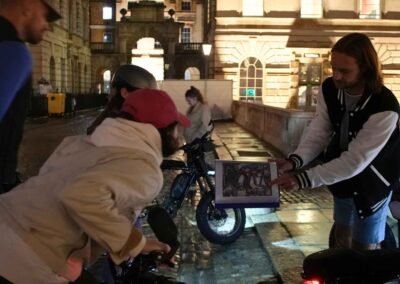 FOF Bike Tours guide showing historical material to guests during the Dickens Christmas e-bike tour at Somerset House.
